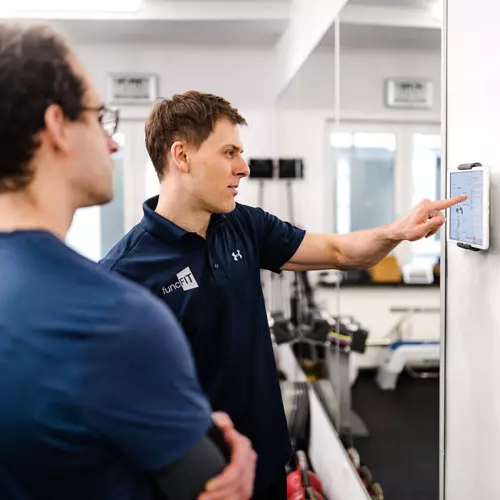 Trainingsplan wird erläutert vom Personal Trainer